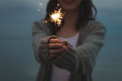فتاة تمسك بشرارة تلألأ في الهواء