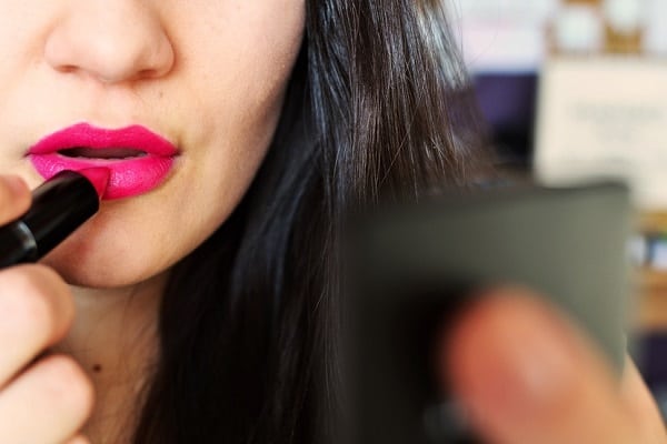 امرأة جميلة تضع أحمر شفاه