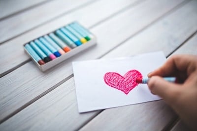 شخص يرسم قلب بألوان