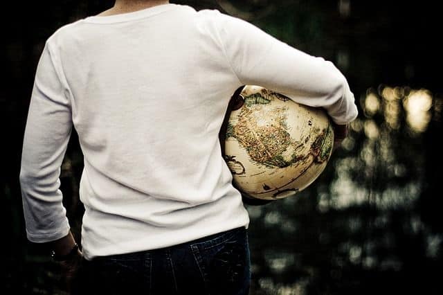 شاب يحمل كرة على شكل الكرة الأرضية